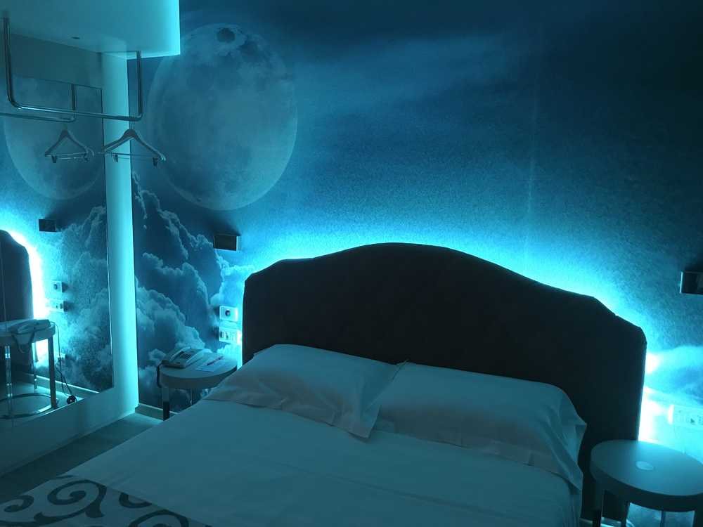 Camera con illuminazione azzurra e parete a tema luna